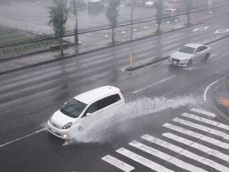 大雨の中飛沫をあげて走る車